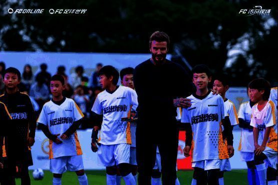 青训小将与贝克汉姆进行绿茵对话的现场照片，背景为《FC足球世界》游戏展台