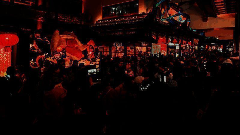 夜幕下豫园灯会流光溢彩，游客驻足欣赏融合游戏元素的传统花灯