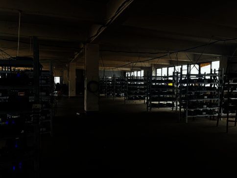 警方查获千余台用于批量注册游戏账号的设备,现场设备堆叠整齐,部分贴有标签,显示为自动化操作工具