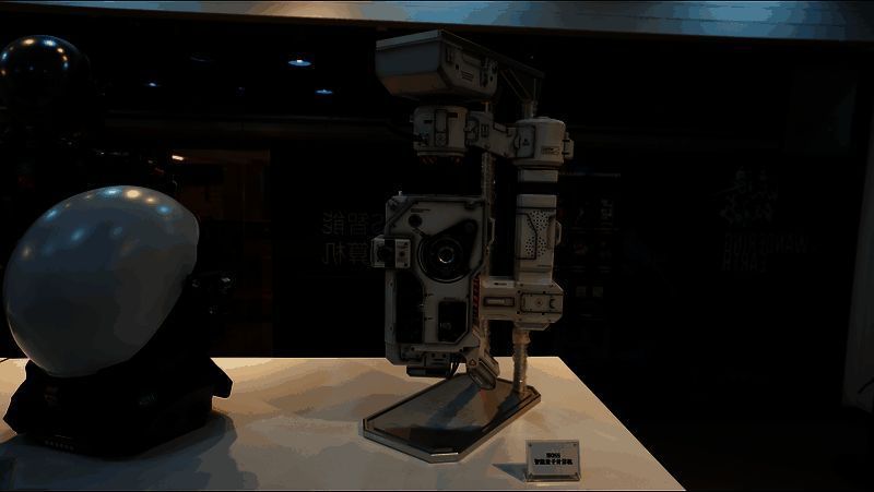 观众试穿《流浪地球》同款外骨骼装备,神情兴奋,背景为MOSS全息投影