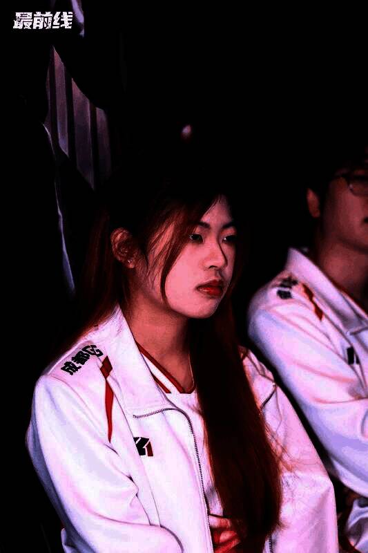 GG_violet与队友在赛后合影,笑容灿烂,背景为战队旗帜与赛事横幅