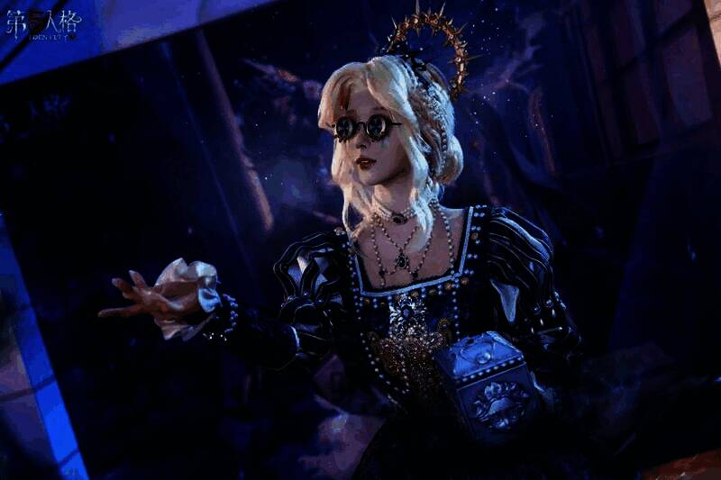 隐士COSER身披斗篷立于展台旁,背景为雪山剪影,氛围神秘