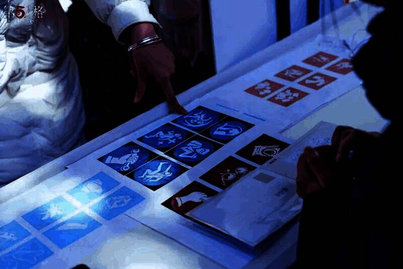 玩家正在参与‘赏雪拓画’手工活动,专注地在纸上拓印雪花图案