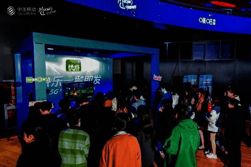 动感地带品牌展区全景,展台设计科技感十足,学生正在体验互动装置