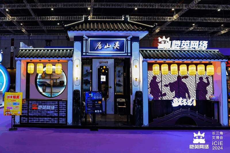 恺英网络展台全景图,灯光炫丽,人群聚集,背景为《盗墓笔记:启程》主题布景