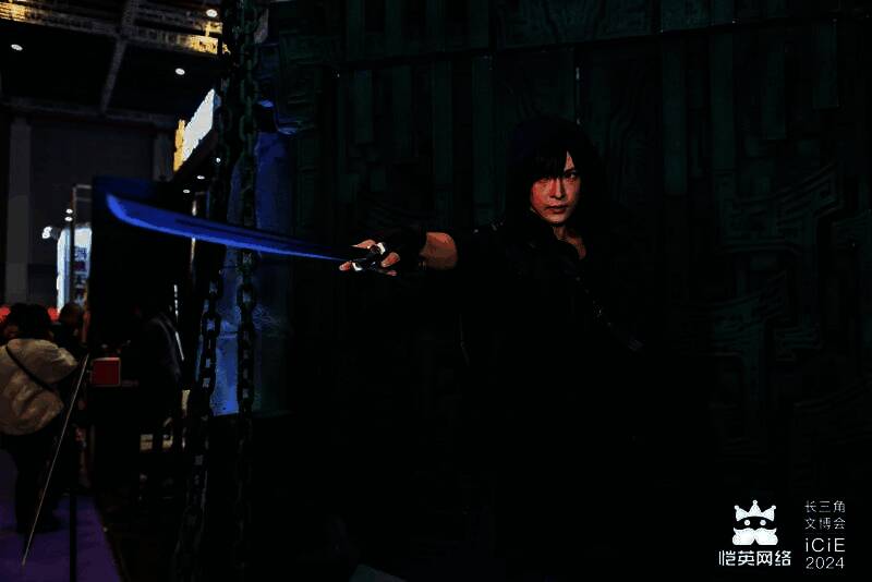 COSER扮演的张起灵与吴邪站在展台中央,周围粉丝兴奋合影,现场氛围热烈